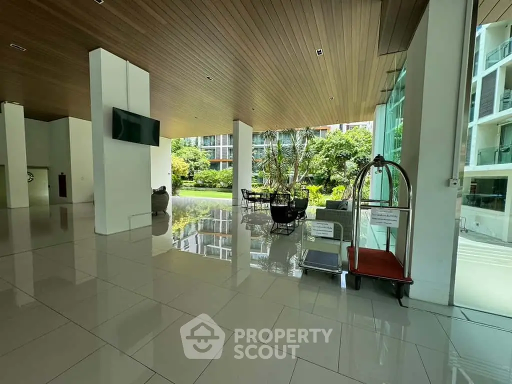 Spacious modern building entrance with garden view and sleek design.