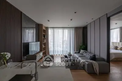 Modern open-plan living room with stylish decor and city view, featuring a cozy seating area and sleek kitchen.