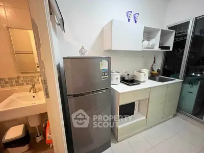 Modern kitchen with sleek appliances and open shelving, adjacent to a compact bathroom.