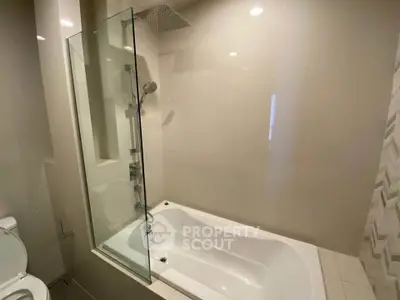 Modern bathroom with sleek bathtub and glass shower partition