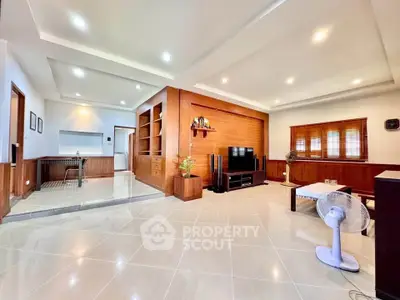 Spacious modern living room with elegant wood paneling and recessed lighting