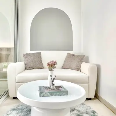 Chic modern living room with cozy white sofa and stylish round coffee table, perfect for relaxation.
