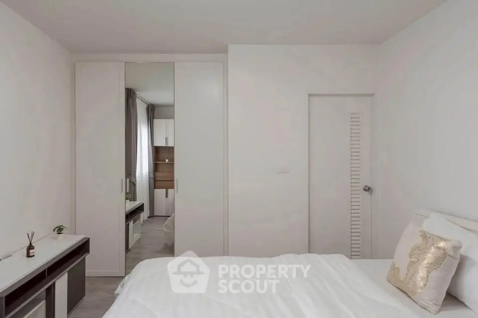 Modern minimalist bedroom with white decor and built-in wardrobe