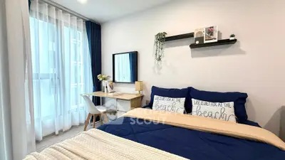 Modern bedroom with stylish decor and natural light, featuring a cozy bed and functional workspace.