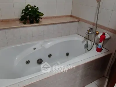 Spacious bathroom with a luxurious bathtub and elegant tile design.