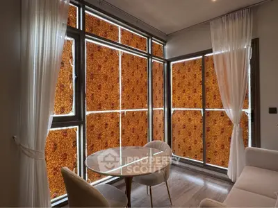 Modern living room with large windows and elegant curtains, featuring a cozy seating area and stylish decor.