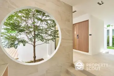 Modern minimalist entrance with circular window and natural light