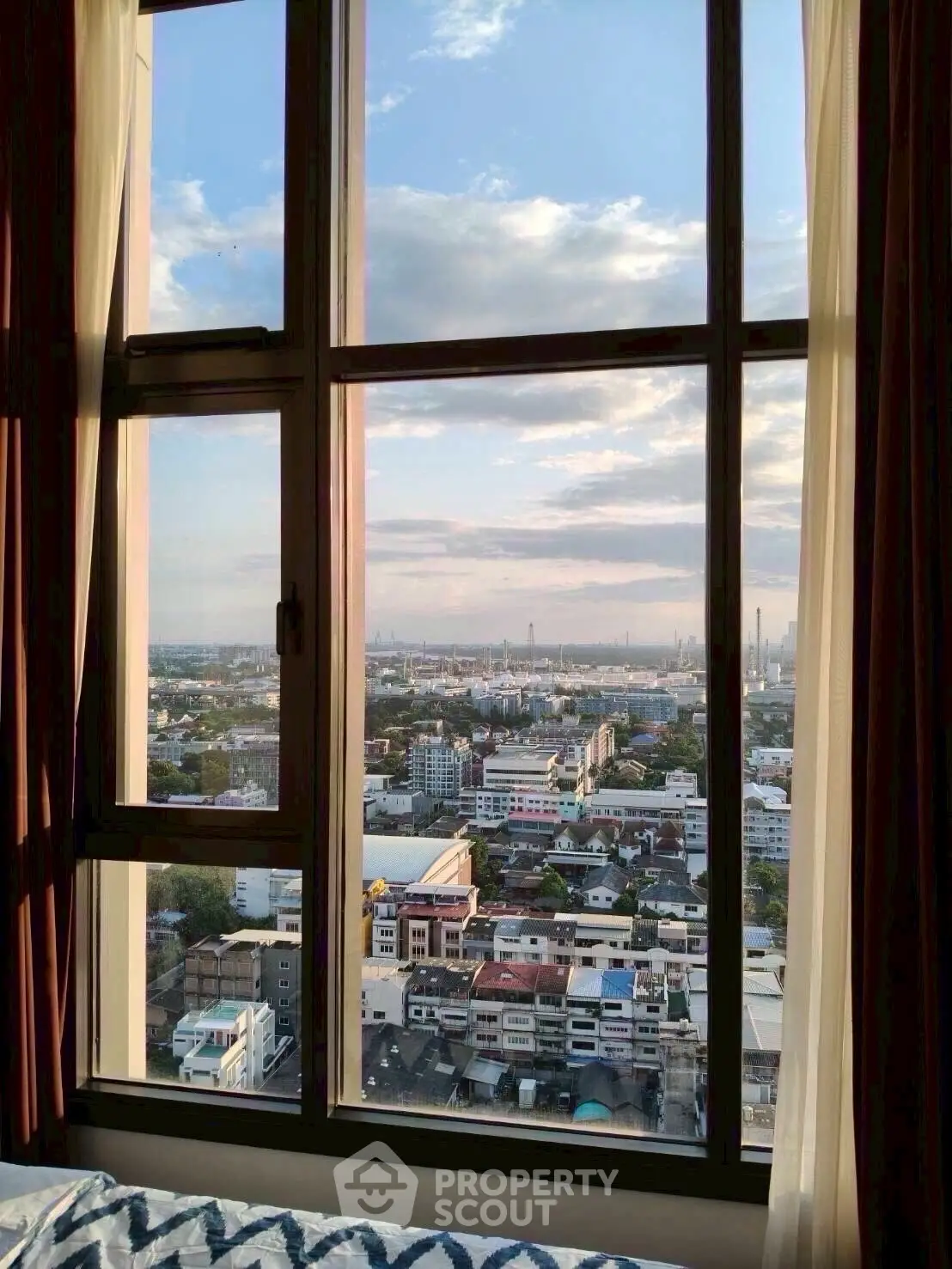Stunning cityscape view from a high-rise apartment window at sunset.