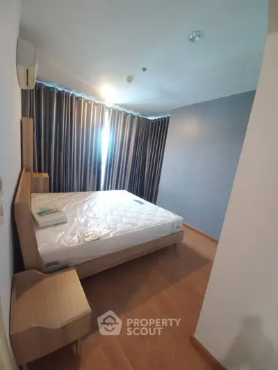 Spacious bedroom with large window and modern furnishings
