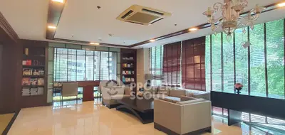 Luxurious living room with elegant seating and large windows offering natural light and garden views.