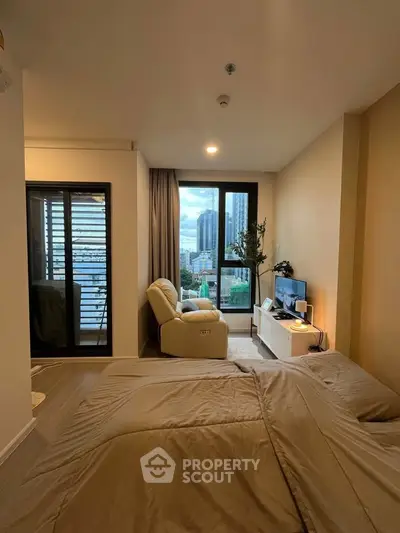 Cozy bedroom with city view, featuring modern decor and comfortable seating area.