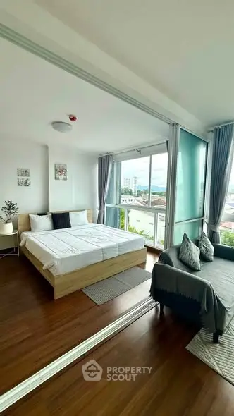 Spacious bedroom with large windows and modern decor, offering a bright and inviting atmosphere.