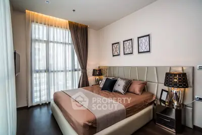 Luxurious bedroom with elegant decor and large window offering natural light.