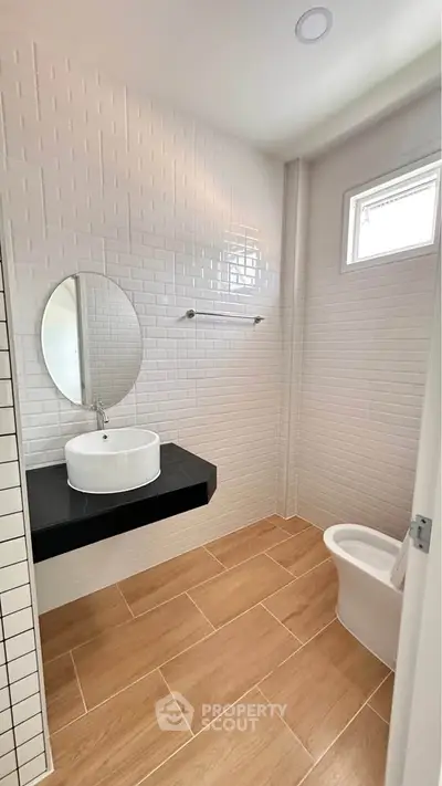 Modern bathroom with stylish round mirror and sleek fixtures