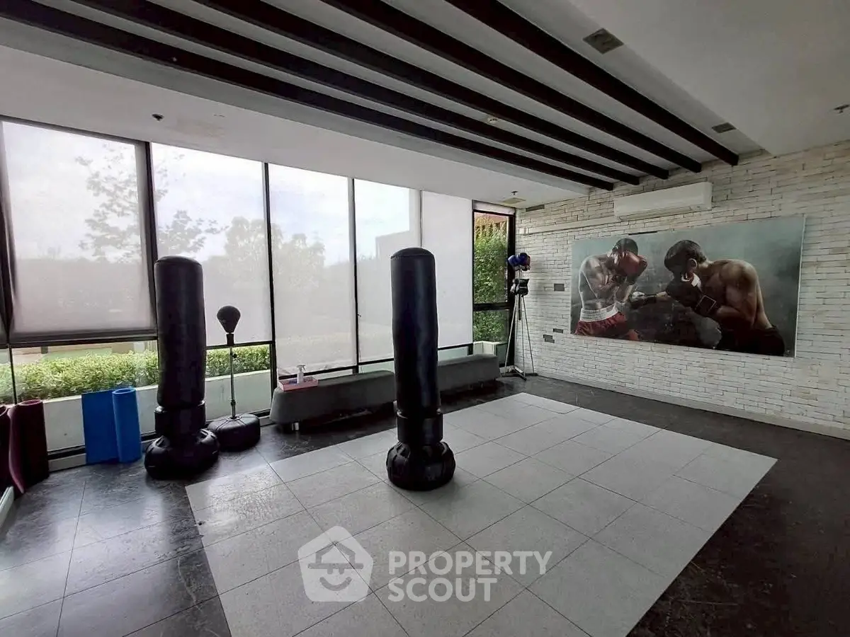 Spacious home gym with boxing equipment and large windows