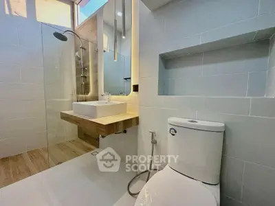 Modern bathroom with sleek design, featuring a glass shower and contemporary fixtures.