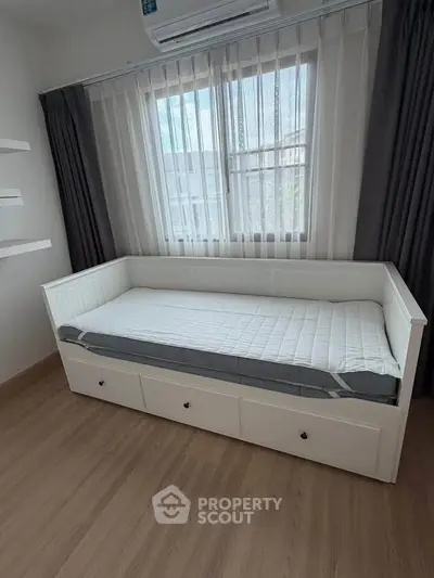 Cozy bedroom with daybed and natural light, perfect for relaxation and comfort.