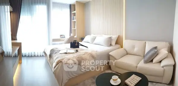 Luxurious modern bedroom with elegant decor and cozy seating area, perfect for relaxation.
