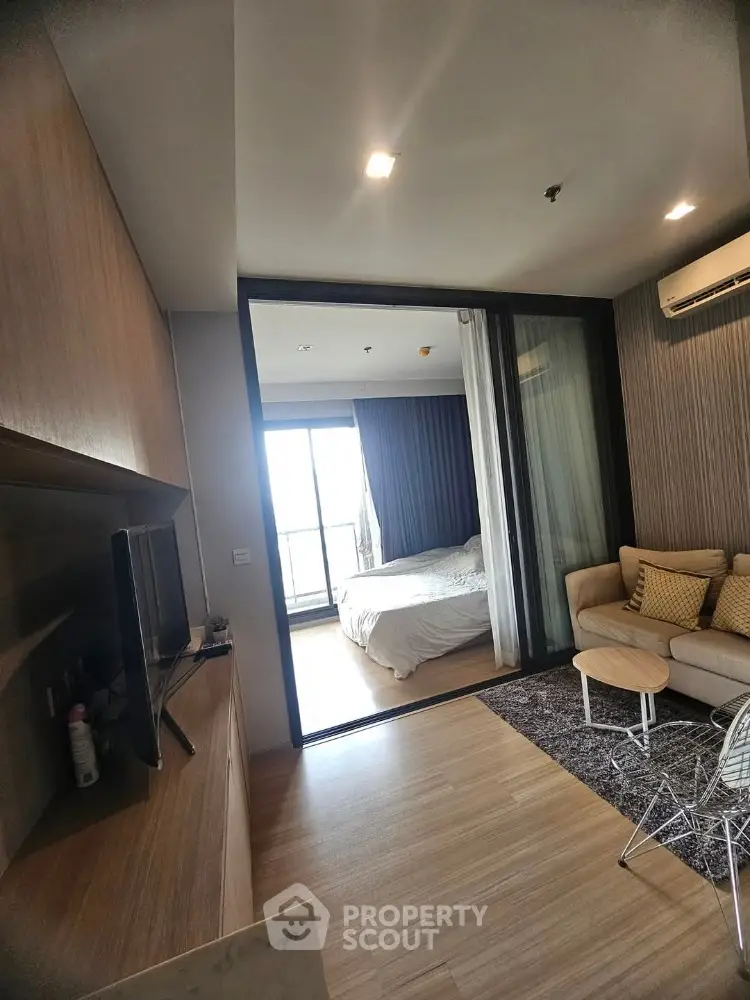Modern apartment interior with cozy living room and bedroom, featuring wooden flooring and stylish decor.