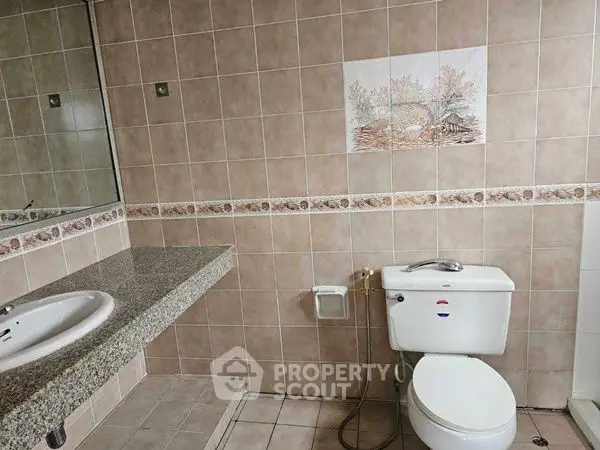 Spacious bathroom with tiled walls and modern fixtures