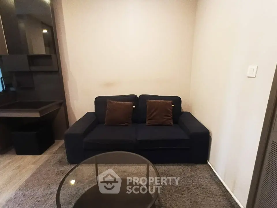 Cozy living room with dark sofa and modern decor in a stylish apartment.