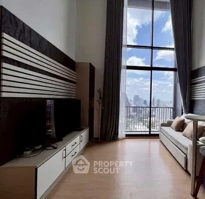Modern living room with large window and city view, stylish decor and natural light.