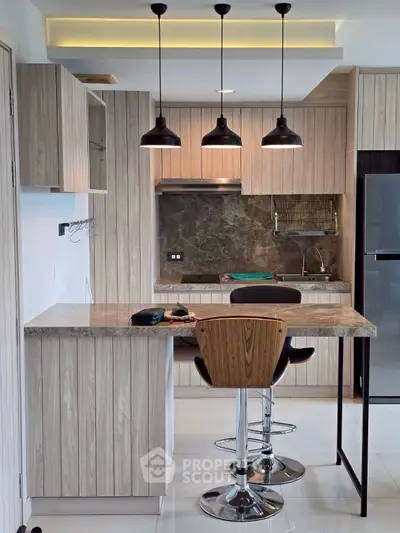 Modern kitchen with sleek cabinetry, breakfast bar, and stylish pendant lighting.