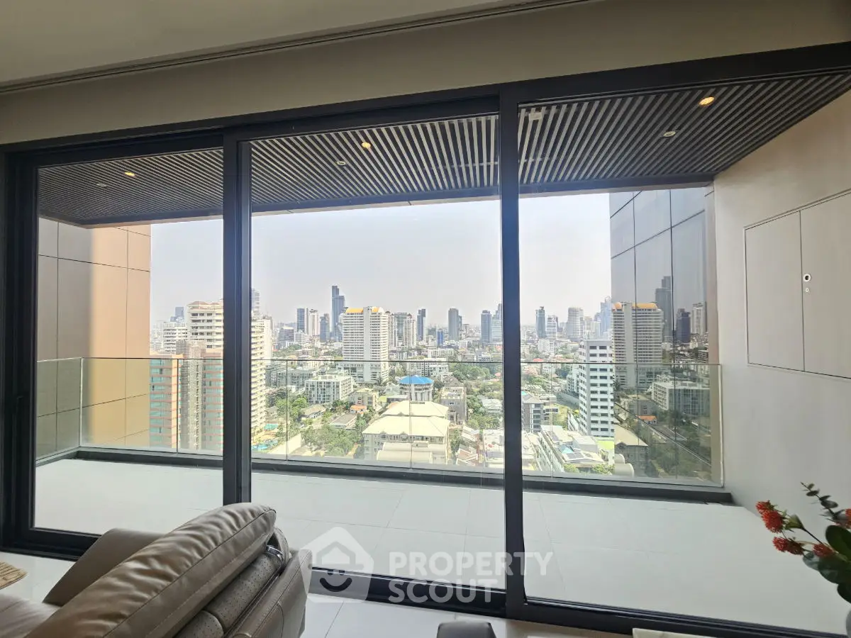 Luxurious high-rise apartment with stunning city skyline view from spacious balcony.