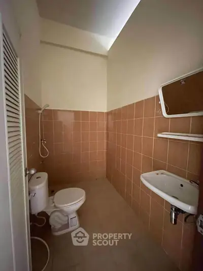 Cozy bathroom with tiled walls and modern fixtures in a real estate property.