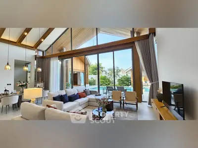 Luxurious living room with high ceilings and pool view in modern villa