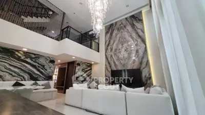 Luxurious modern living room with high ceilings and elegant chandelier