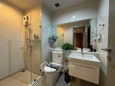 Modern bathroom with glass shower, sleek vanity, and stylish decor
