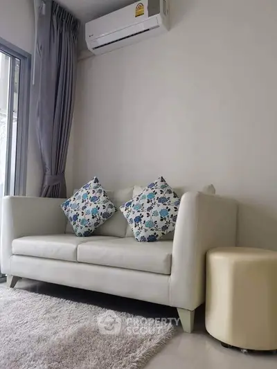 Cozy living room with modern sofa and air conditioning, perfect for relaxation.
