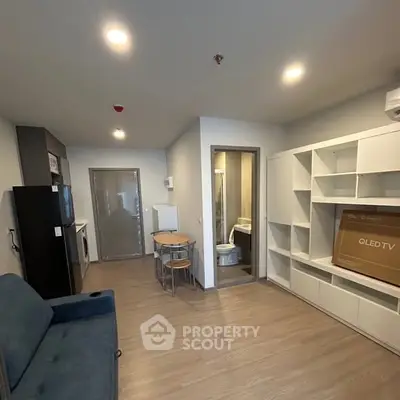 Modern apartment interior with open living area and kitchen, featuring sleek furniture and ample storage.