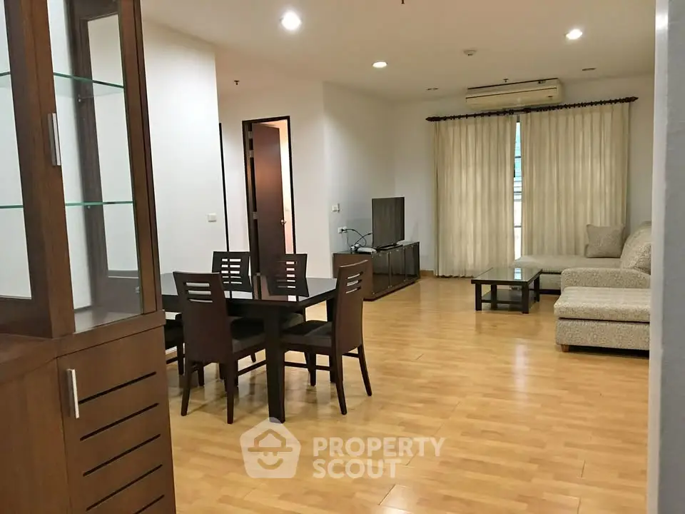 Spacious living room with modern furniture and wooden flooring in a cozy apartment.
