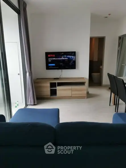 Modern living room with sleek furniture and wall-mounted TV, perfect for relaxation and entertainment.