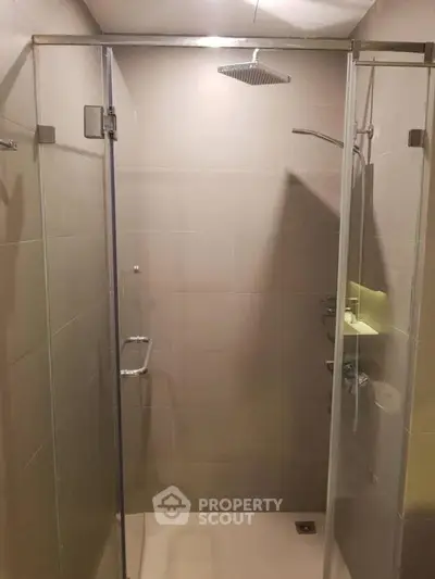 Modern bathroom with glass shower enclosure and rainfall showerhead.