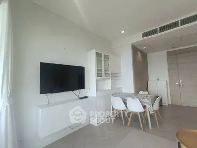 Modern living room with sleek furniture and mounted TV in a stylish apartment.
