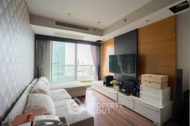 Modern living room with large window and city view, featuring cozy sofa and entertainment center.