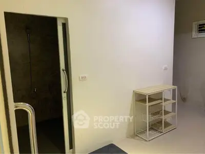 Minimalist interior with open shower and storage shelves, ideal for compact living spaces.