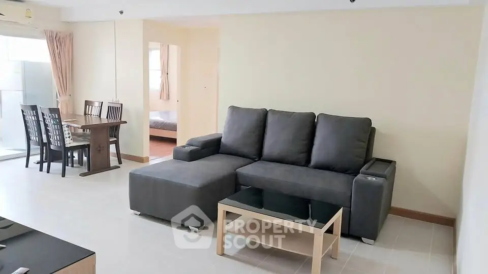 Spacious living room with modern furniture and dining area in a bright apartment.