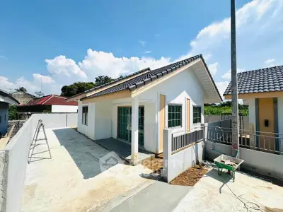 Charming single-story house with modern design and spacious driveway under a clear blue sky.