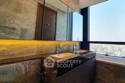 Luxurious bathroom with dual sinks and city view from large window