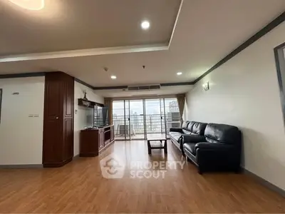 Spacious living room with modern furnishings and city view balcony.