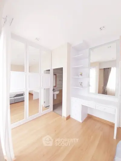 Bright and spacious bedroom with elegant wooden flooring and built-in wardrobe