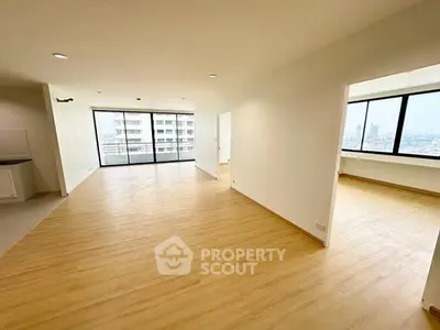 Spacious modern apartment with open layout and large windows offering city views.