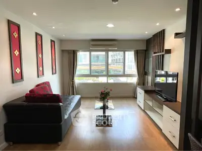 Modern living room with stylish decor, large window, and sleek furniture in a bright apartment.