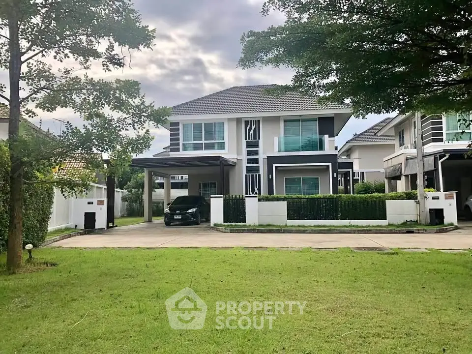 Modern two-story house with a spacious front yard and driveway in a serene neighborhood.