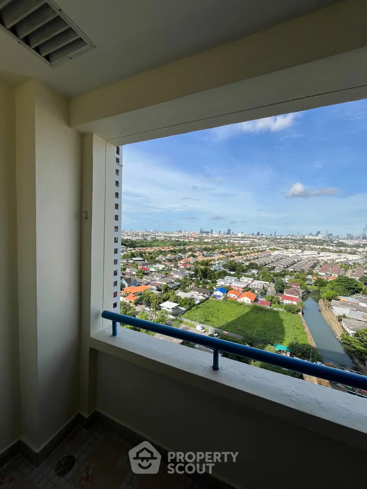 Stunning cityscape view from high-rise balcony with clear blue skies.