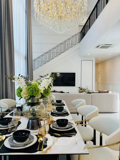 Luxurious modern living room with elegant dining area and stunning chandelier